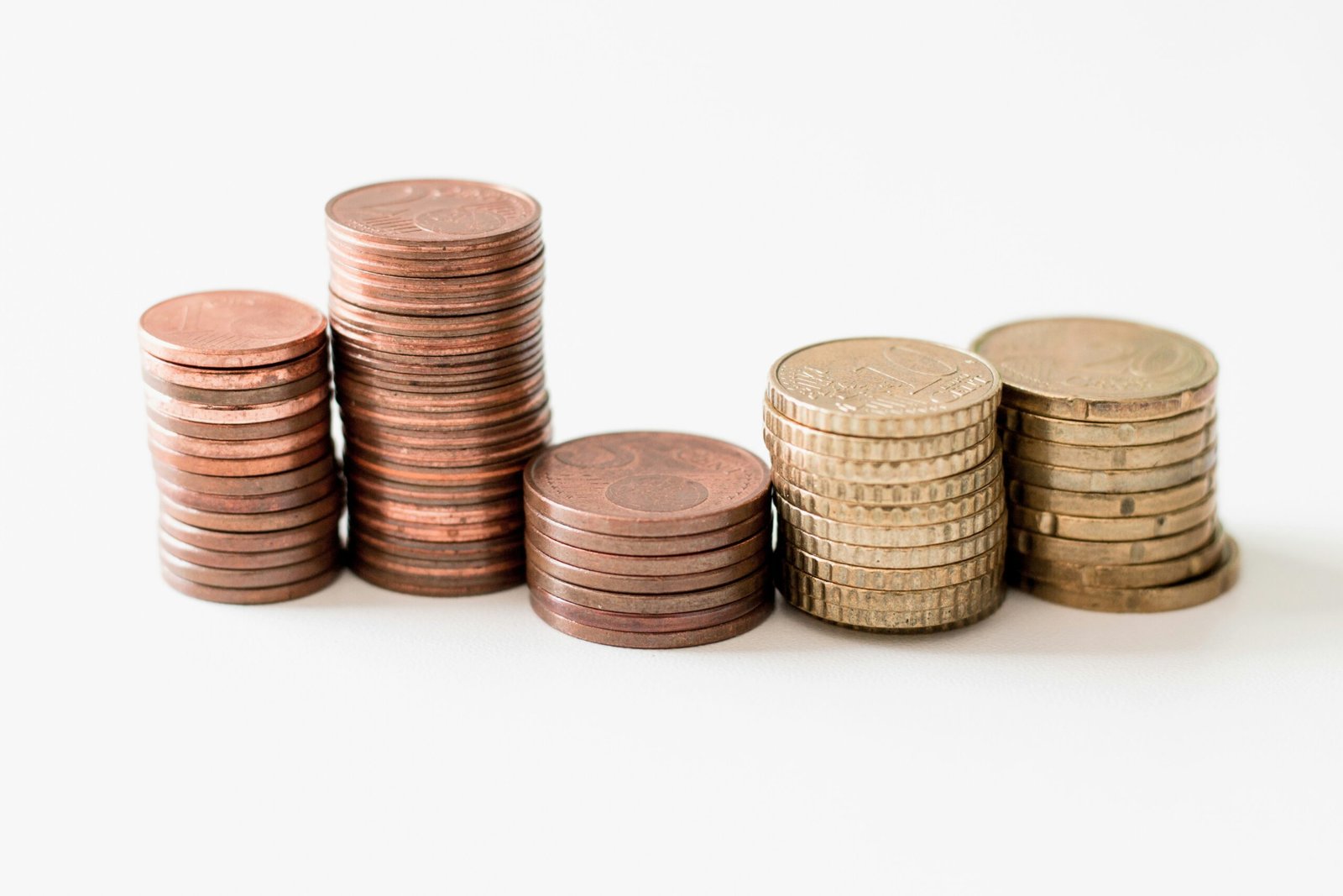 stacked round gold-colored coins on white surface